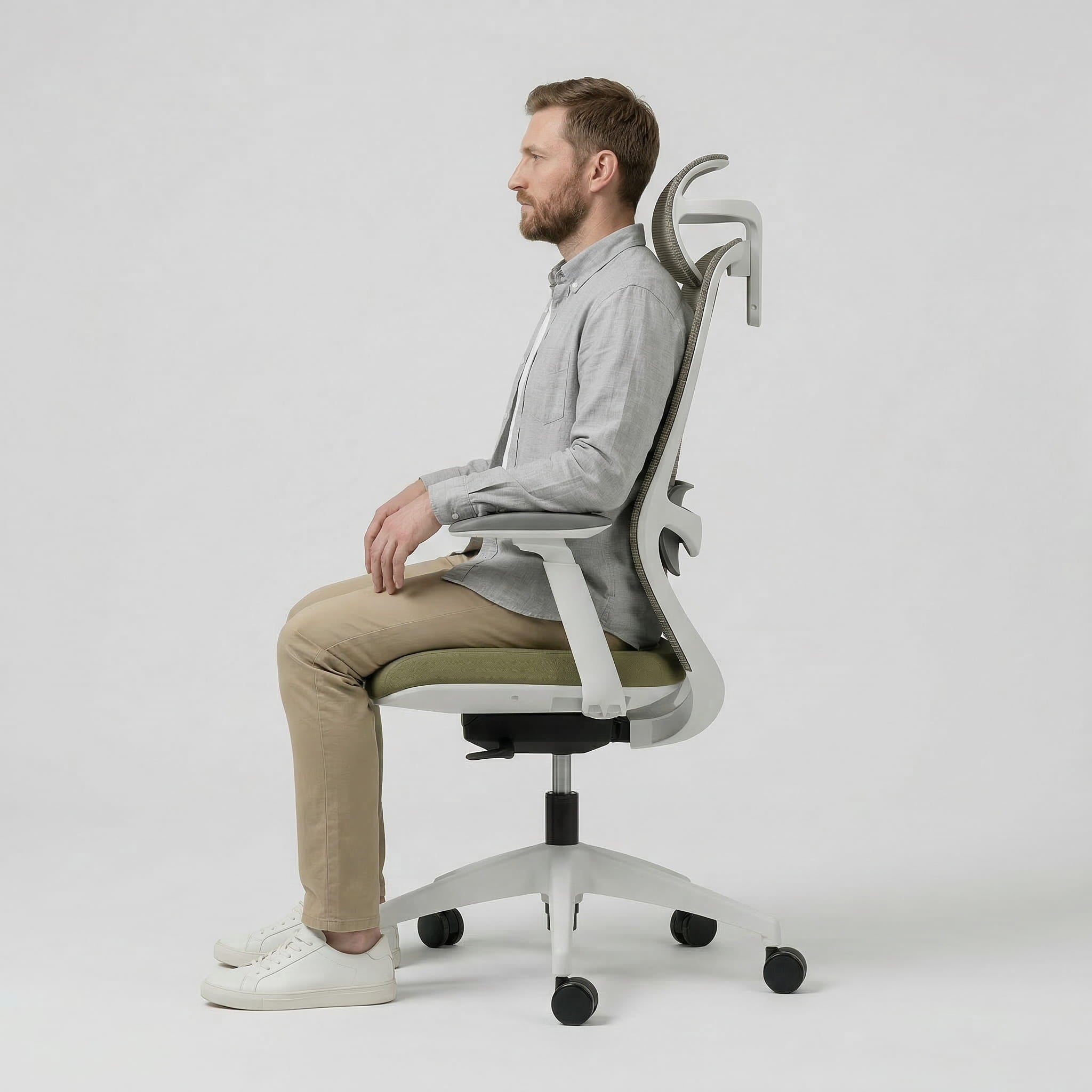 Man sitting on a modern office desk chair with a unique backrest design against a white background
