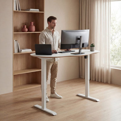 Modern office setup with a white man working at a white height adjustable desk