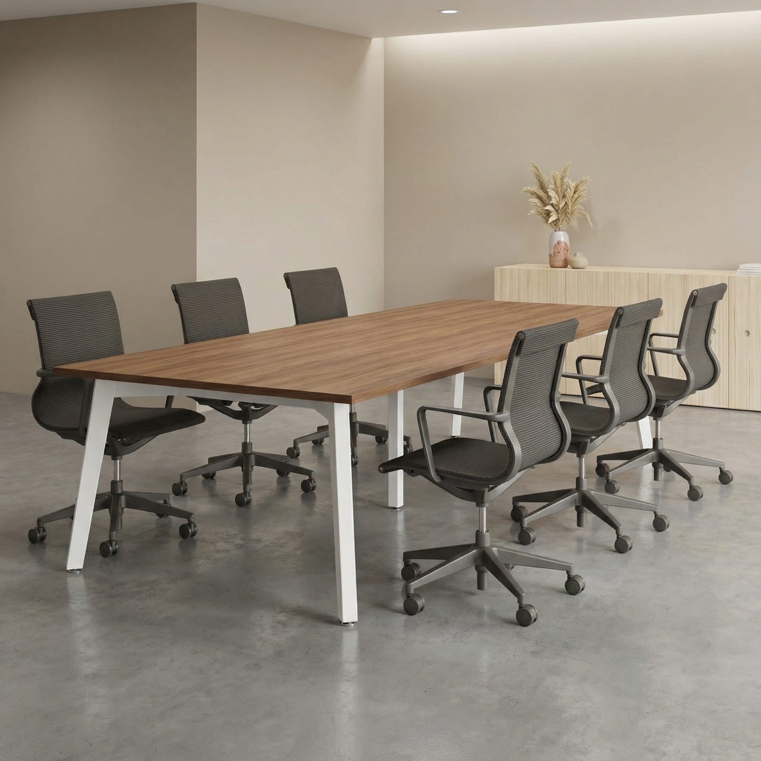 Modern office conference room with a long wooden boardroom table and gray meeting room chairs.
