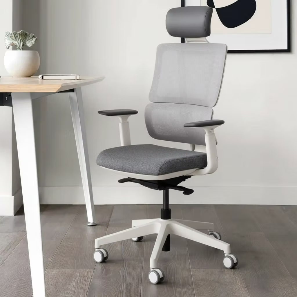 Gray office chair with white base in a room with a desk and plant.