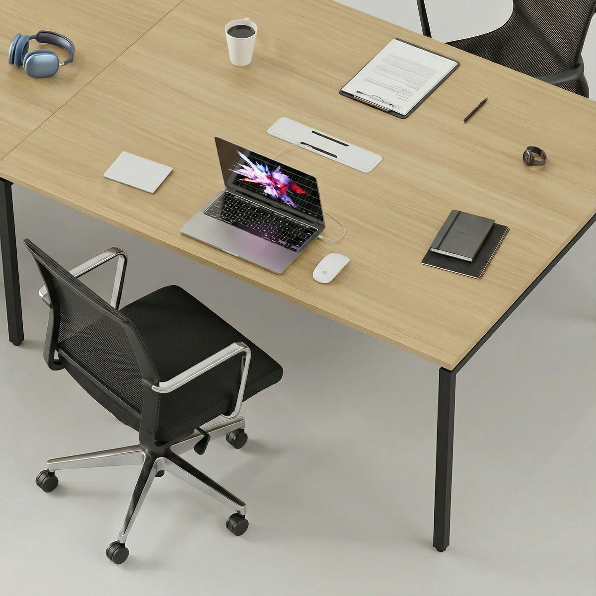 Modern office desk with laptop, mouse, and office supplies on a light gray floor and office seating
