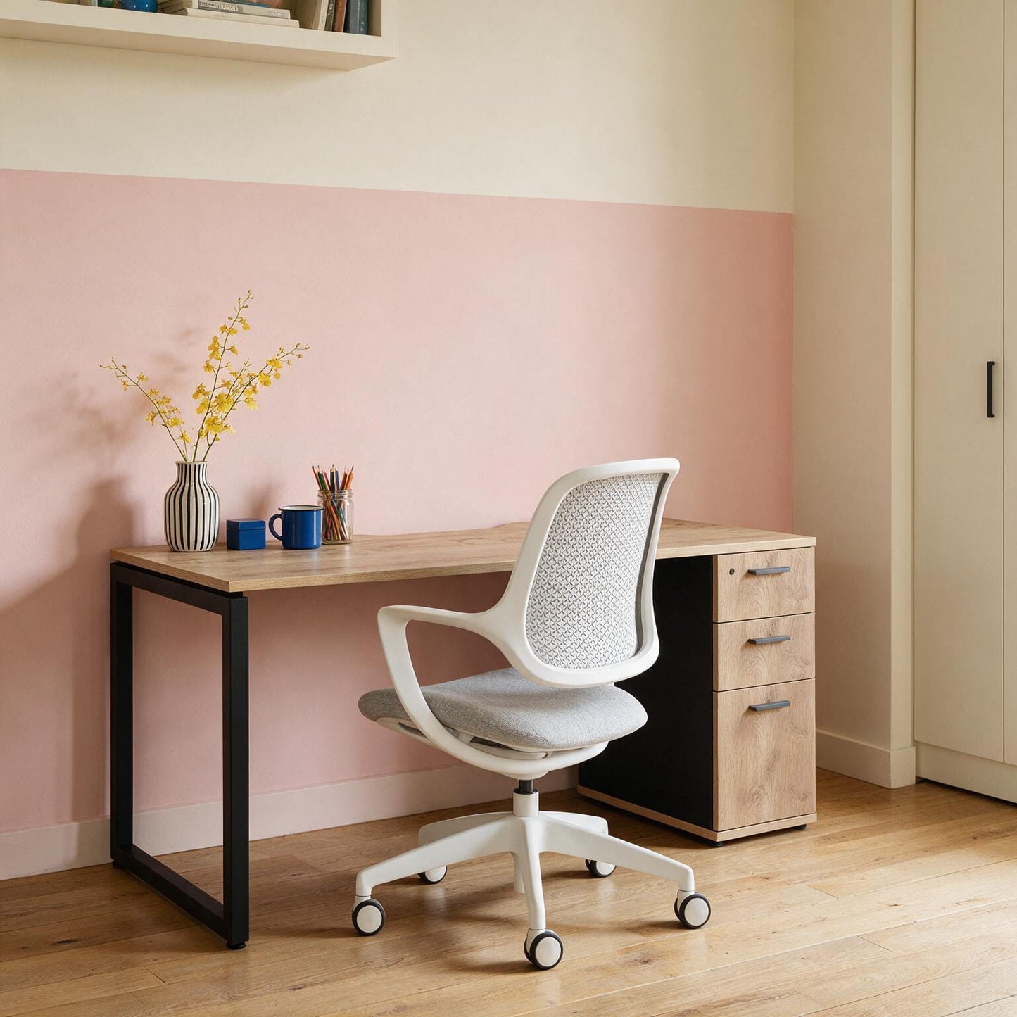 Barrel Oak desk with drawers and a black steel frame, shown from the side with a task chair