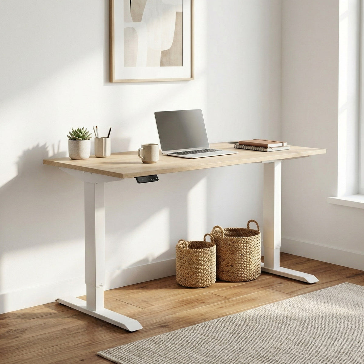 standing desk with white legs and a oak top plus a laptop, mug, and decorative items on top in a bright room. 