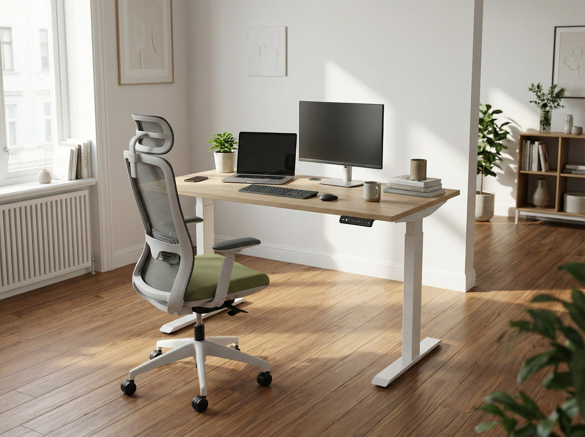 Modern office setup with a white height adjustable desk, white ergonomic office chair, and computer in a bright room.
