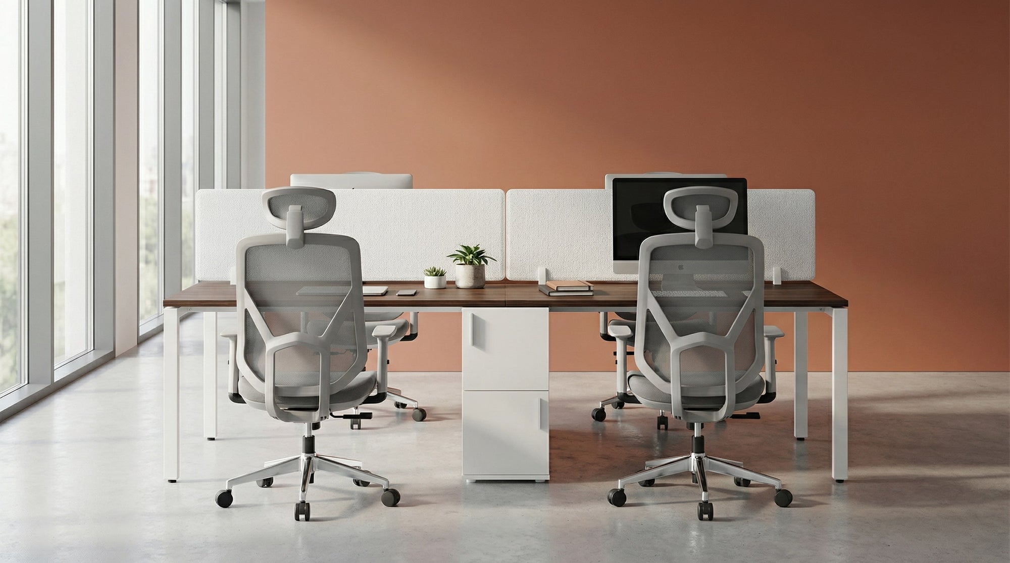 Modern office setup with two desks, ergonomic office chairs, and a computer monitor.