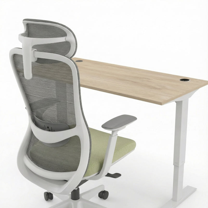 Ergonomic office chair with mesh backrest next to a wooden desk on a white background