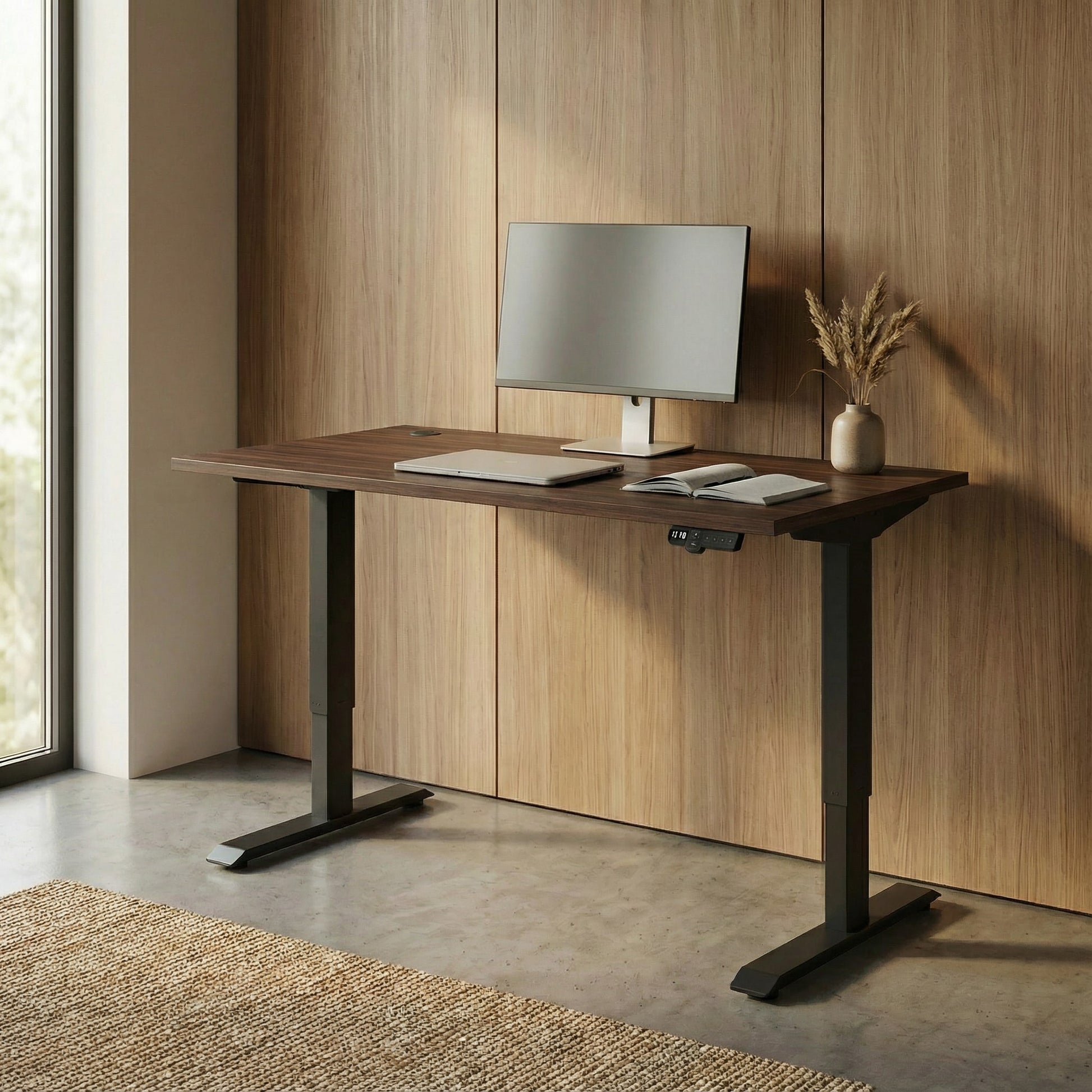 Modern office sit stand desk with a computer setup against a wooden wall.