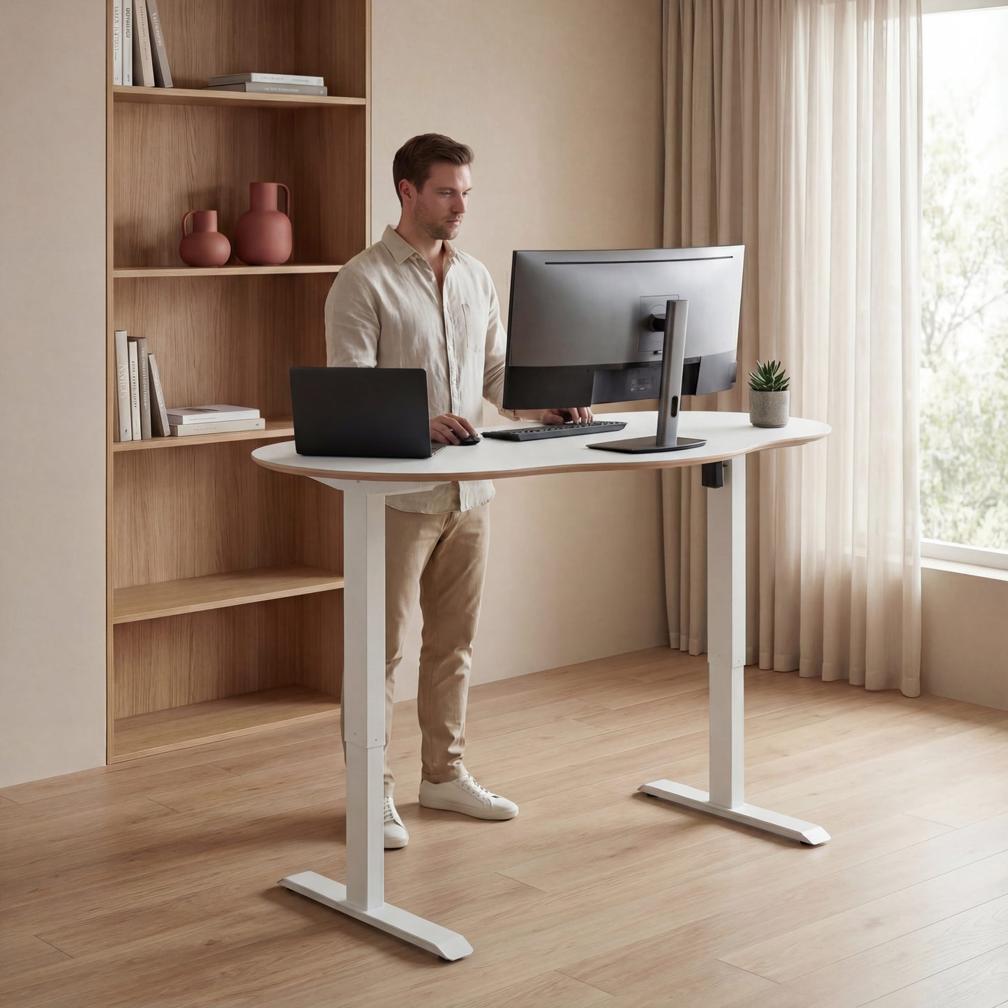 Modern office setup with a white man working at a white height adjustable desk