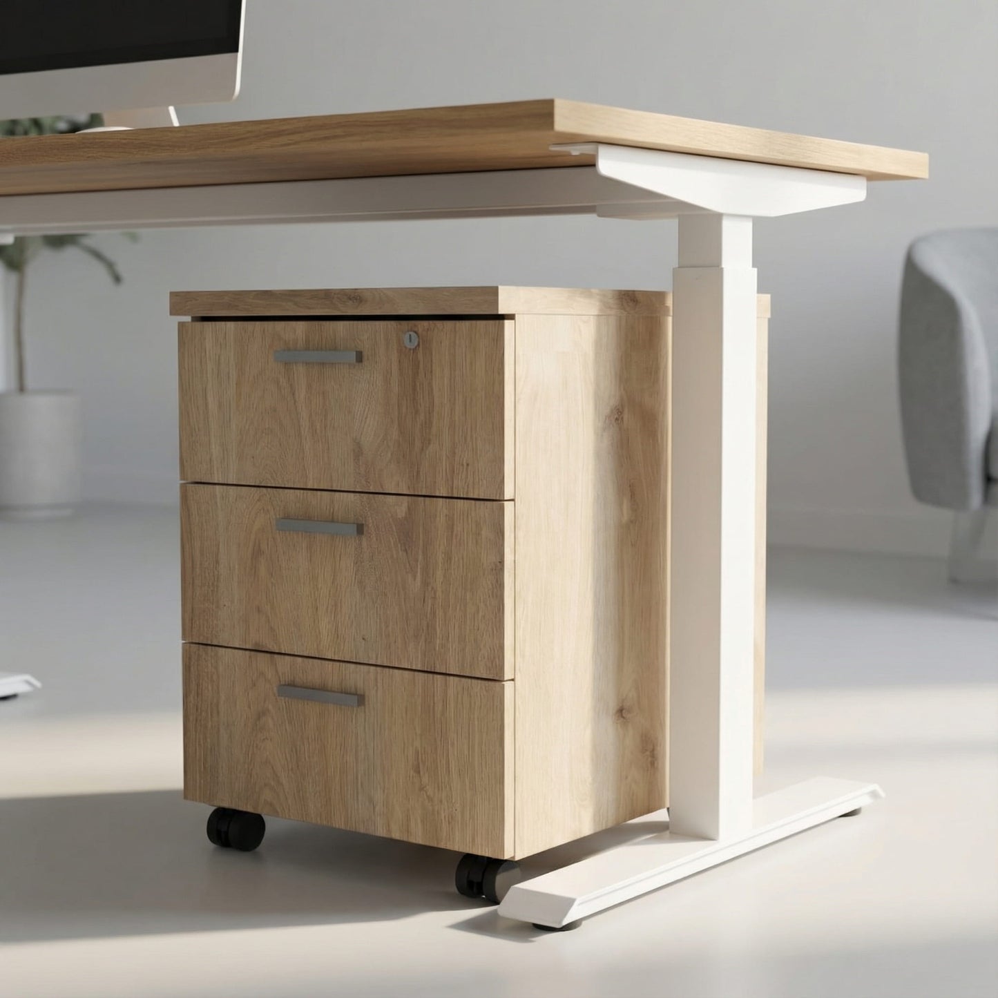 Oak storage with three drawers on wheels under a white framed sit stand height adjustable desk in a modern office room