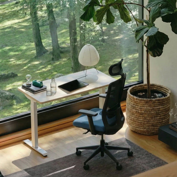 modern desk, home office chair, and large window view of greenery.
