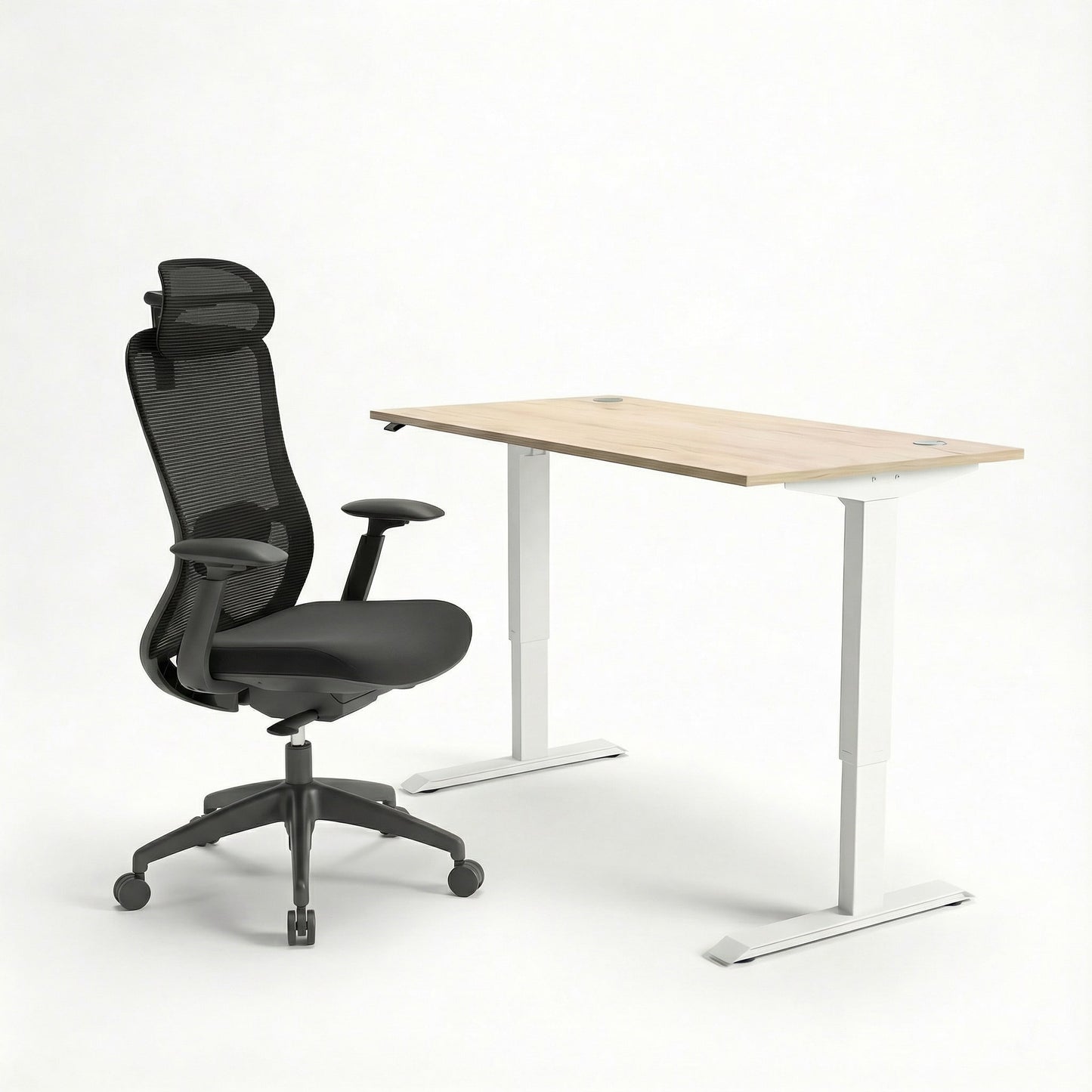 Black ergonomic office chair and height adjustable sit stand desk on a white background