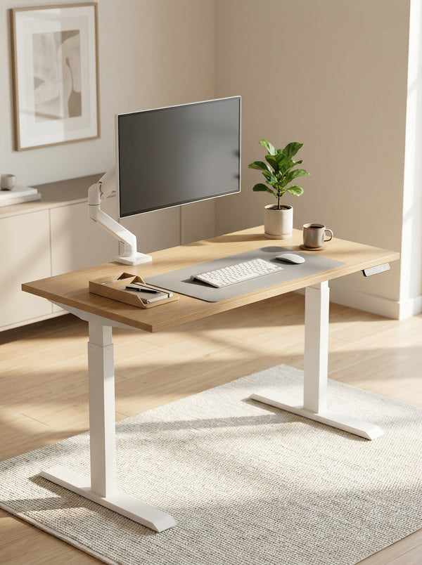 Modern office sit stand desk with screen connected to a monitor arm a bright room on a grey carpet. 