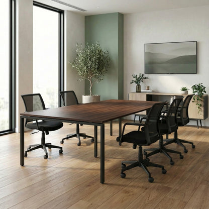 Modern office with a long wooden table and black office chairs, featuring a large window and decorative elements.