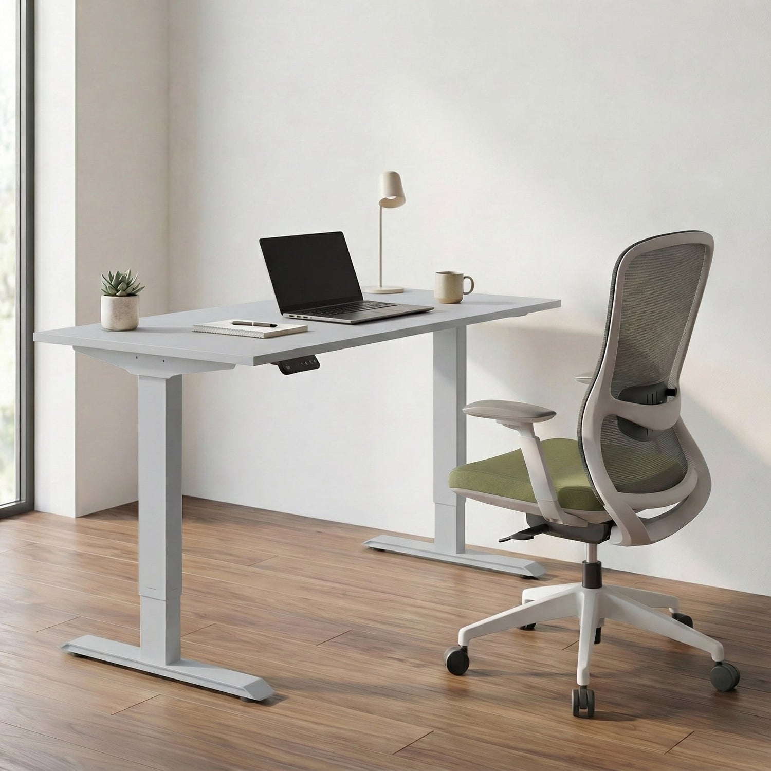 Modern office setup with a adjustable standing desk, ergonomic chair, and laptop.