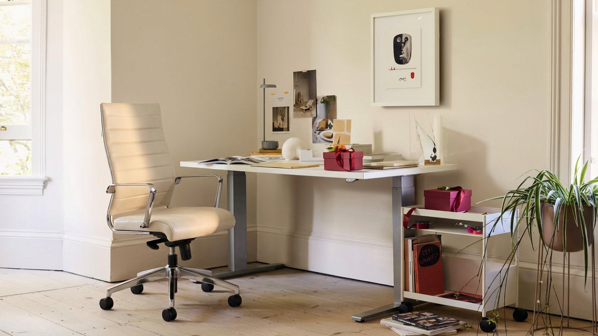 The Boardroom Chair (Open Box) in a bright cream home office beside a white standing desk, wide banner